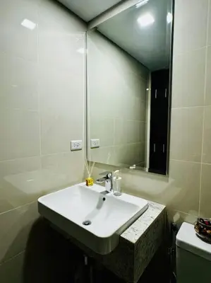 a bathroom with a sink and a large mirror at 10F Luxury 1BR at Park Mckinley West near Venice Mall in Manila