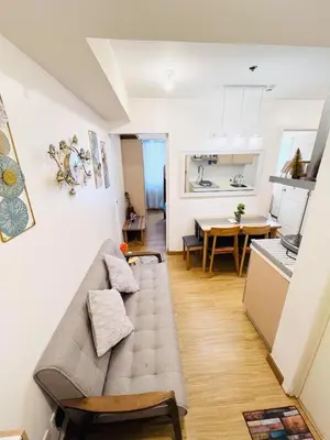 a living room with a couch and a kitchen at Azure Urban Resort Residences in Manila