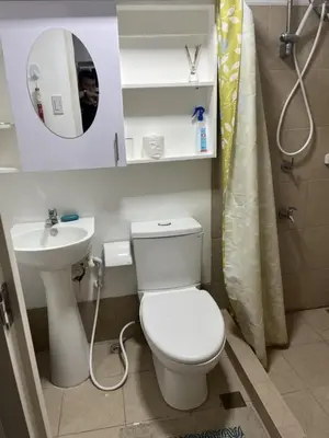 a bathroom with a toilet and a sink and a mirror at STANFORD SUITES 2 UNIT 755 lilian in Silang