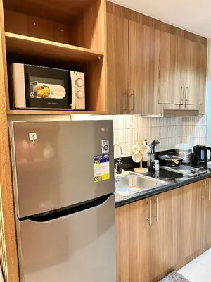 a kitchen with a stainless steel refrigerator and a microwave at Cozy and Aesthetic Condo at Shore 3 in MOA, Pasay in Manila