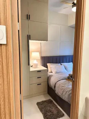 a bedroom with a bed and a nightstand with a lamp at Cozy and Aesthetic Condo at Shore 3 in MOA, Pasay in Manila