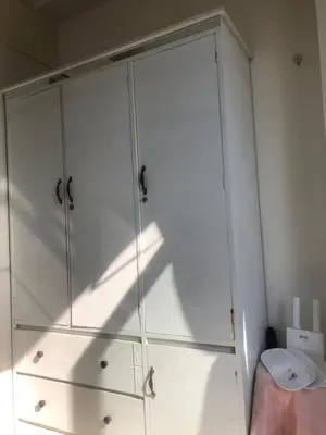 a white cabinet with glass doors in a room at SOUTH Residence Condotel in Manila