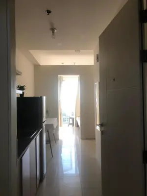 a room with a kitchen and a living room with a window at SOUTH Residence Condotel in Manila