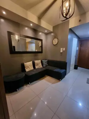 a living room with a couch and a mirror at Shell Residences - 1 br no balcony in Manila