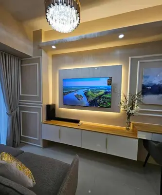 a living room with a flat screen tv on a wall at Cozy apartment near Airport in Shore 3 in Manila
