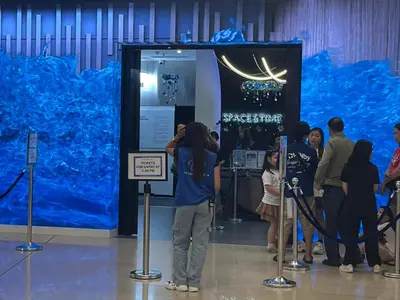 a person taking a picture of a large blue exhibit at Shore 2 2-Bed Balcony City View WiFi Netflix near MOA 834 in Manila