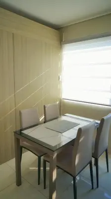 a dining room with a glass table and chairs at SM Breeze one bedroom in Manila
