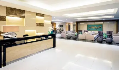 a lobby with couches and chairs in a building at SM Breeze one bedroom in Manila