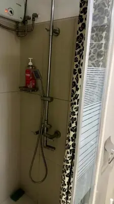 a shower with a monkey shower curtain in a bathroom at Kathys Crib with balcony Pool view at Shell Residence in Manila