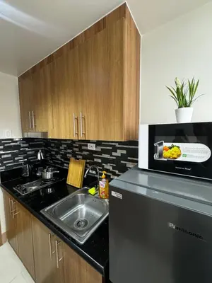 a kitchen with a sink and a counter top at Bachelor Pad Shore 3 Residences in Manila