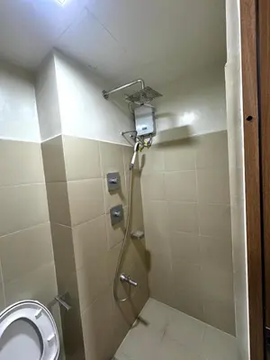 a shower stall in a bathroom with a toilet at Bachelor Pad Shore 3 Residences in Manila