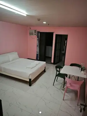 a bedroom with a bed and a table and chairs at cartimar hotel condo in Manila
