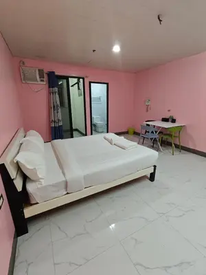 a bedroom with a large bed and a table at cartimar hotel condo in Manila