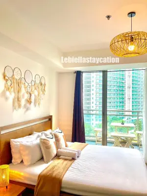 a bedroom with a large bed with a chandelier at azure urban resort residences in Manila