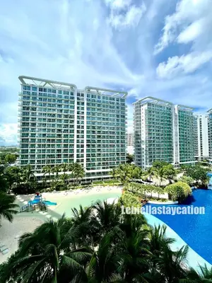 a view of a resort with a beach and palm trees at azure urban resort residences in Manila