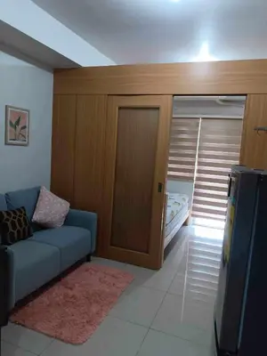 a living room with a couch and a bed at Shell Residences Condotel Apartment in Manila