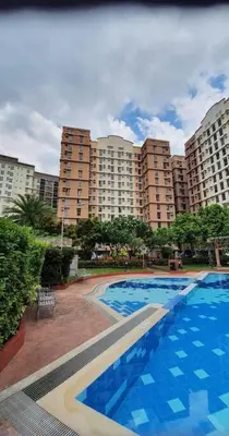 a large swimming pool in front of a large building at Near Manila Airport COZY 02 Bedroom Condo With Pool - 4R in Manila