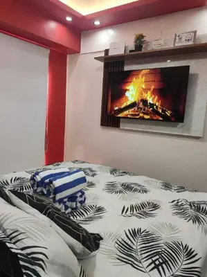 a bedroom with a bed with a fireplace on the wall at Near Manila Airport COZY HOTEL STYLE Condo With Pool 7A in Manila