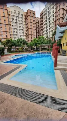 a large blue swimming pool with buildings in the background at Near Manila Airport COZY 01 Bedroom Condo - 10L in Manila