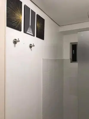 a bathroom with a shower with pictures on the wall at Near Manila Airport COZY 01 Bedroom Condo - 10L in Manila