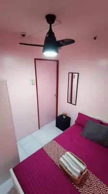 a bedroom with a purple bed and a ceiling fan at Near Manila Airport COZY 01 Bedroom Condo - 10K in Manila