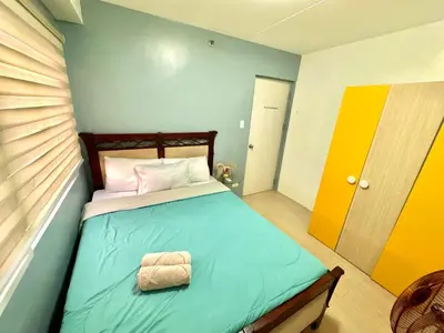 a small bedroom with a bed with a blue bedspread at Luna Hive Place in Malapandan