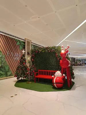 a christmas display with a red bench and a christmas tree at Cozy Staycation at Destiny's Crib Fame, Edsa Mandaluyong in Manila