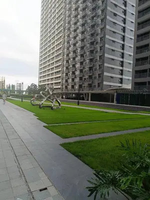 a park with a sculpture in front of a large building at Cozy Staycation at Destiny's Crib Fame, Edsa Mandaluyong in Manila