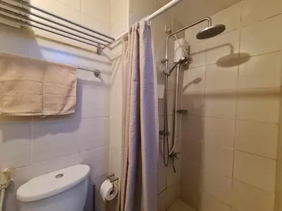 a bathroom with a shower curtain and a toilet at Jazz Residences Luxury Staycation in Manila