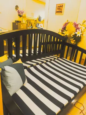 a black and white bench with pillows on it at Sea Residences Condotel GudStay in Manila