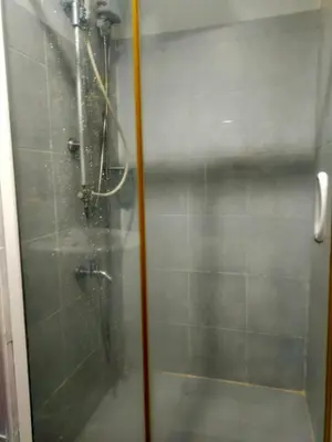 a shower with a glass door in a bathroom at Sea Residences Condotel GudStay in Manila