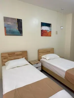 two beds in a room with paintings on the wall at W Spot Property in Manila