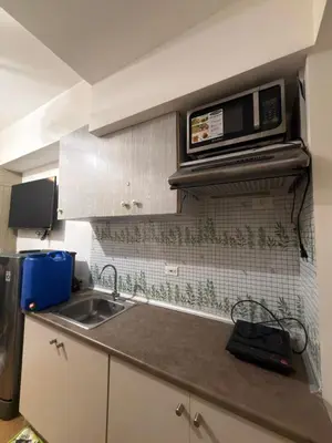 a kitchen with a sink and a microwave at Netflix and Chill at Ephra Homestay - Grace Residences Tower 4 in Manila