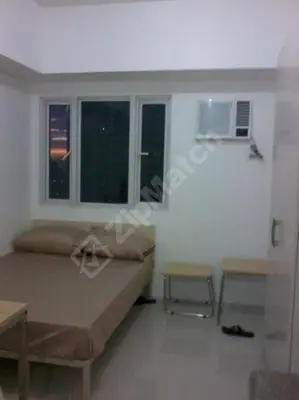 a room with a bed and two tables and two windows at 20th flr SMDC Lights Residence Mandaluyong City Philippines in Manila