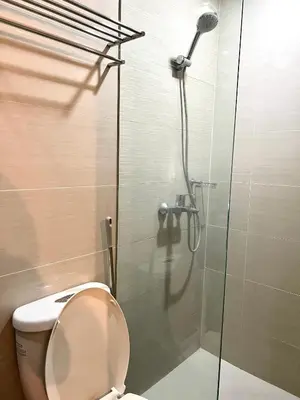 a bathroom with a toilet and a glass shower at Deluxe Studio with Balcony at Greenbelt Makati Manila in Manila