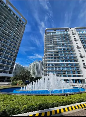 a water fountain in front of a large building at DT SUITES AND RESORTS at Azure Paranaque in Manila