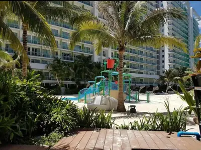 a playground in front of a large building at DT SUITES AND RESORTS at Azure Paranaque in Manila