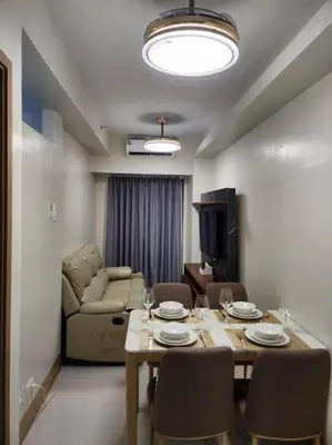 a living room with a table and chairs and a couch at Mocha Flat at Shore 3 Tower 4 in Manila