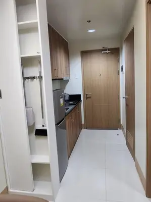 a small kitchen with a refrigerator and a door at Mocha Flat at Shore 3 Tower 4 in Manila