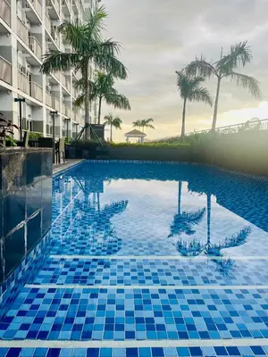 a large swimming pool with blue tiles in a building at Coast Residences condo near MOA, StarCity and PICC in Manila
