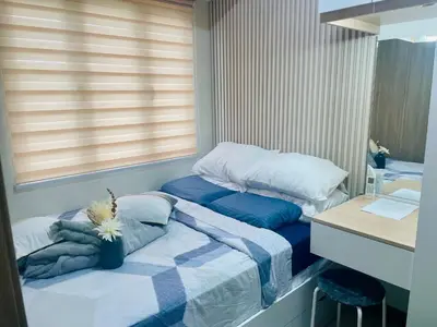a small bedroom with two beds and a desk at Coast Residences condo near MOA, StarCity and PICC in Manila