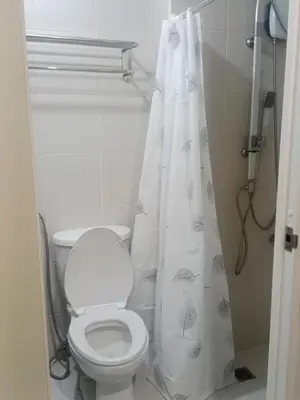 a bathroom with a toilet and a shower curtain at Jazz staycation in Manila