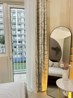 a bedroom with a mirror and a window at Espacio Tres in Manila