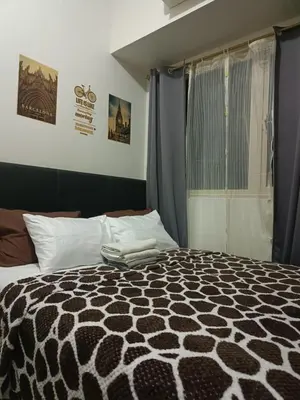 a bedroom with a black and white bed with a window at Coast Residences-Ronnzel staycation in Manila