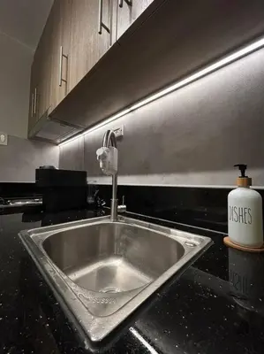 a kitchen counter with a sink in a kitchen at BALAY MULANO at FAME RESIDENCES MANDALUYONG CITY l with balcony pool view l 200mbps wifi in Manila