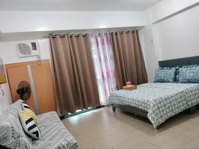 a bedroom with two beds and a couch in it at Room Across NAIA Terminal 3 Two palm tree in Manila