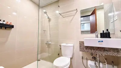 a bathroom with a shower and a toilet and a sink at BGC High Rise, Uptown Mall Link, 5G WiFi, Pool, Ste 29 in Manila
