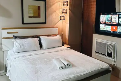 a hotel room with a bed with two towels on it at The Serenity Studio in Manila
