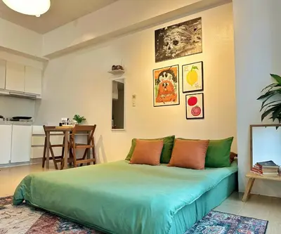 a bedroom with a green bed and a kitchen at Studio in Eastwood Fast Wifi Free Pool & Gym in Manila