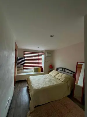a bedroom with a large bed and a window at bendetto residences in Manila